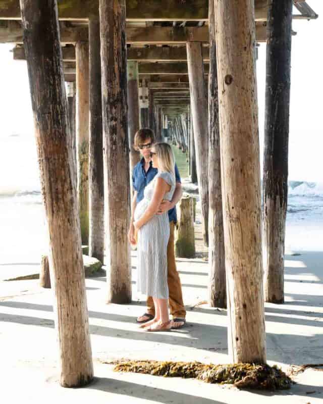 couple standing under the wooden wharf in Capitola California - Top photos sites on a California Road Trip