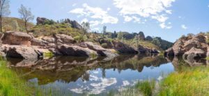 reflection of rocks and hills at the reservoir in Pinnacles National Park - Road Trip Highlights