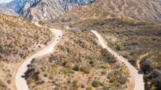 Black car driving around a hair pin turn in Sequoia National Forest