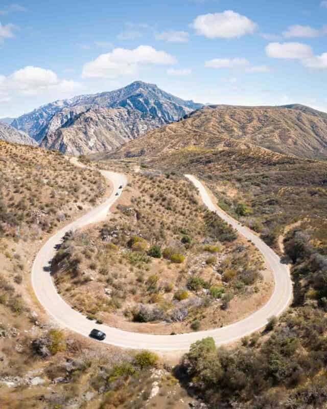 Black car driving around a hair pin turn in Sequoia National Forest