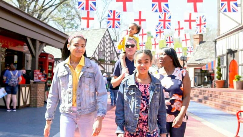 family walking through Busch Gardens Williamsburg with flags above their heads - Top things to do in Williamsburg