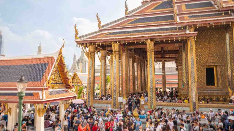 busy afternoon at the Grand Palace with golden tile covered traditional Thai architecture - Top Things to do in Bangkok