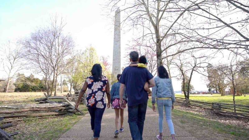 a family walking toward the statue of Historic Jamestown - Top historical Sights near Williamsburg