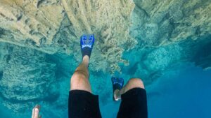 view of snorkel fins submerged in very clear waters of Kayangan Lake in Coron - Best activities in the Palawan Philippines