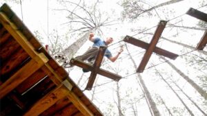 Man walking on a rope course in williamsburg VA - Go Ape Adventure Park