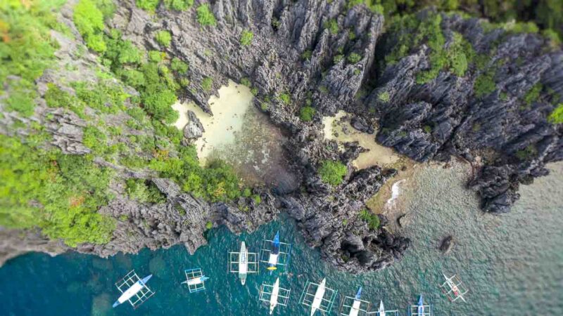 Aerial View of Secret Beach - tall limestone cliff surround a hidden beach