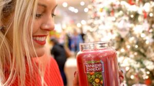 Woman smelling a Yankee Candle at the Williamsburg Store - Must Visit