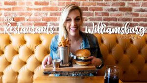 Woman holding a hamburger for the cover image of "Best Restaurants in Williamsburg Virginia" Text overlaid