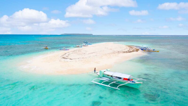 Drone Photo of Naked Island in Siargao - Small sand bank island surrounded by turquoise water and traditional Philippine boats
