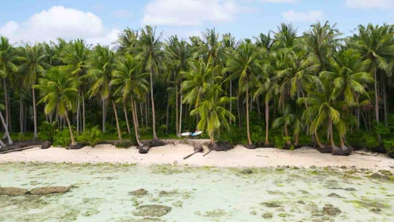 Two surfers walking on Secret Beach in Siargao