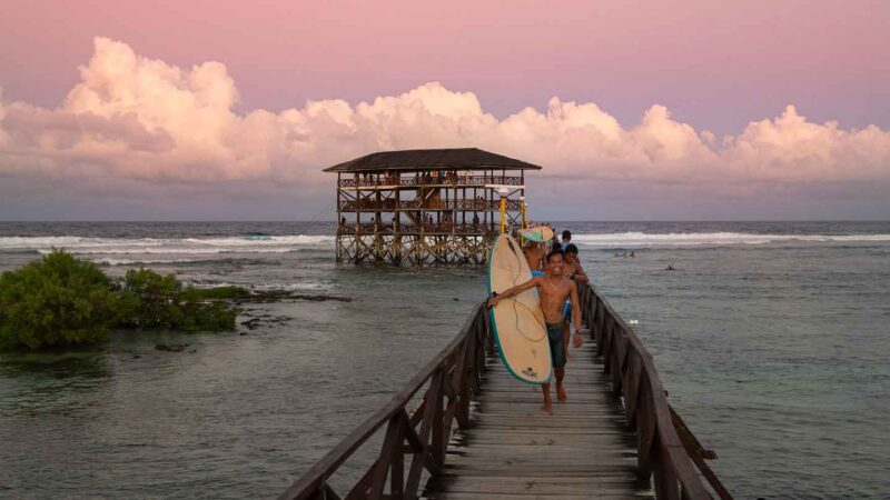 Men carrying surfboards on the Cloud 9 Pier - Surfing in Siargao