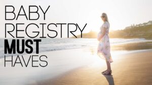 Pregnant Woman standing on the beach in a light pink dress - Baby Registry Must Haves Featured Iamge