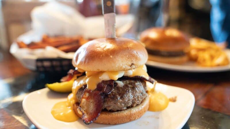 Large burger name the cheesehead from Crafty Cow Restaurant in Bayview with a knife stuck into the top of the bun