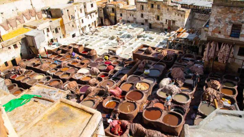 Men dying leather at the Fez leather tanneries - Places to visit in Morocco