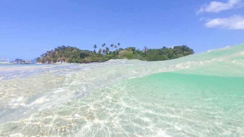 over under photo of the waters near snake island in El Nido 