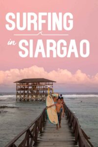 Pink sunset with surfers at Cloud 9 in Siargao