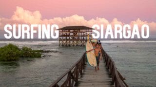 pink sunset at cloud 9 Siargao with surfers carrying surf boards