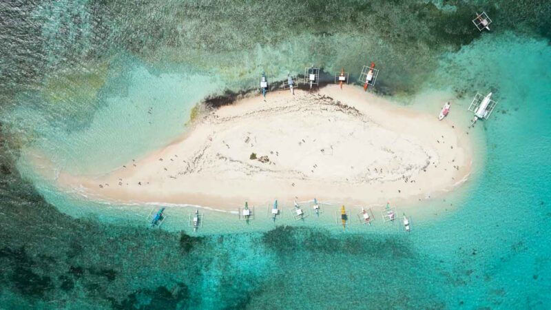 top down view from a drone of Naked Island with traditional boats anchored