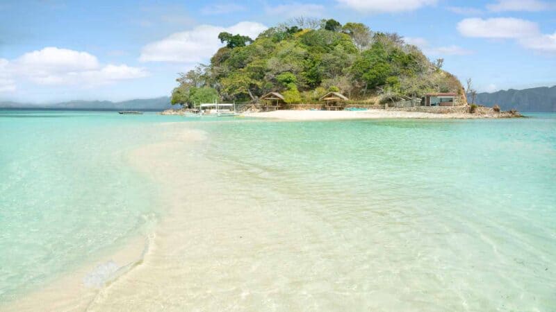 small dome shaped island with a tin strip of sand in front of it