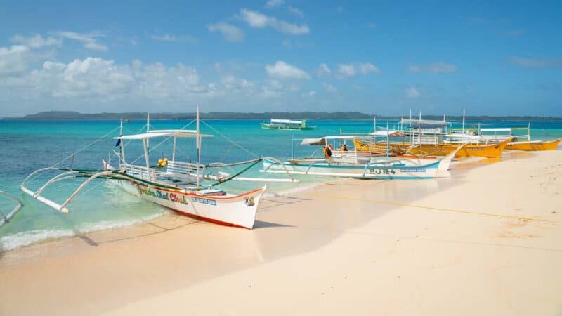 Day trip boats parked on the beach of Daku island