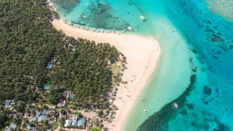 large sandy point of Daku island as seen from a drone