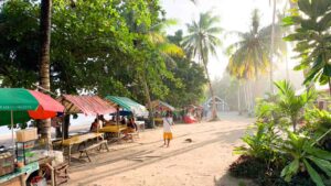 Food stalls with colorful umbrellas in land from the beach area of Magpupungko rock pools on Siargao Island