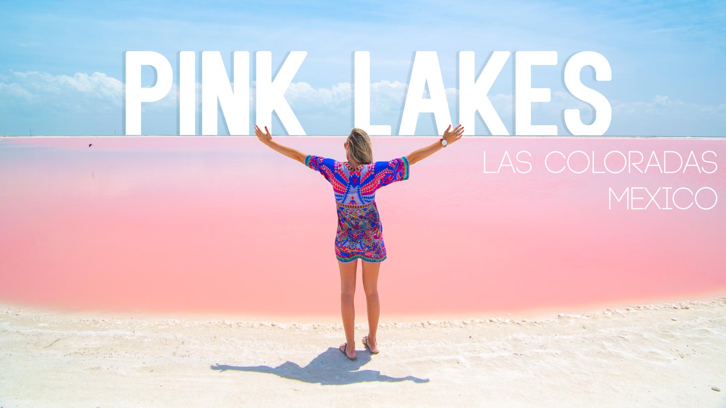 Woman with arms in the air infront of the pink lakes of las coloradas mexico - Featured image