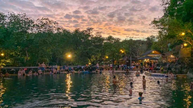 View looking over the hot springs in Coron called the Maquinit during a pink and orange sunset - Things to do in Coron