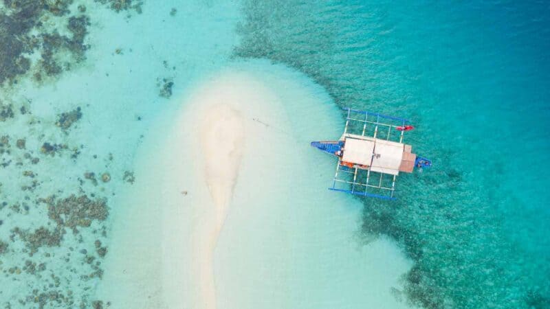 Top Down Drone Photo of Bulog Dos Island - traditional boat in clear water near a sandbar