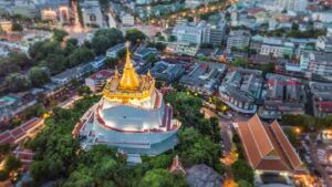View looking down at the famous Wat Saket Golden Mountain temple located in Bangkok Thailand at night with lights on