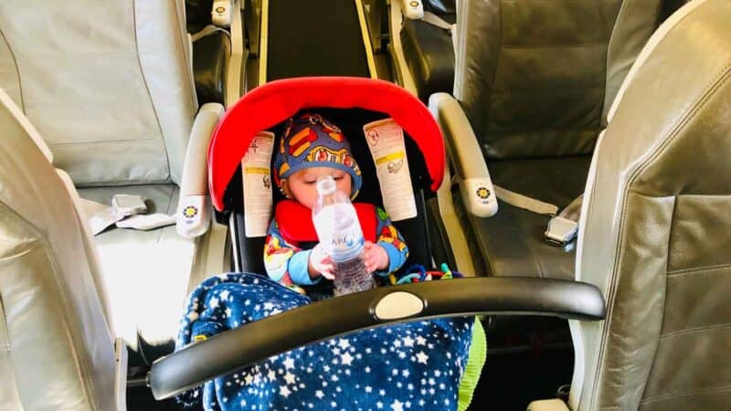 baby in Doona going down the airplane aisle