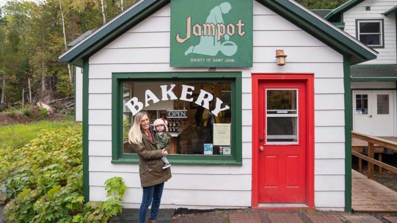 Woman and baby in front of the white build of Jampot Bakery