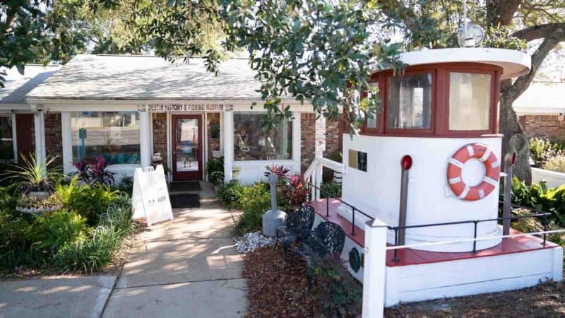 exterior view of the Destin Fishing Museum - White building with ship parts decorating the grounds