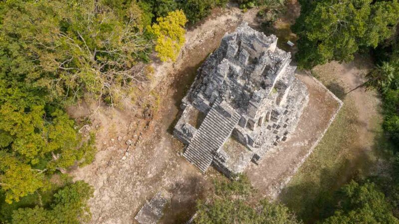 Aerial Drone Photo of a large stone mayan pyramid of Muyil ruins surrounded by lush jungle