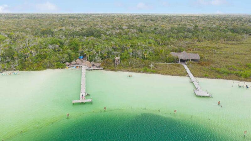 Drone photo of Kaan Luum showing greenish blue water and long wooden docks