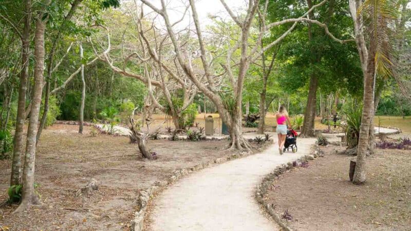 woman pushing a stroller at Muyil Ruins