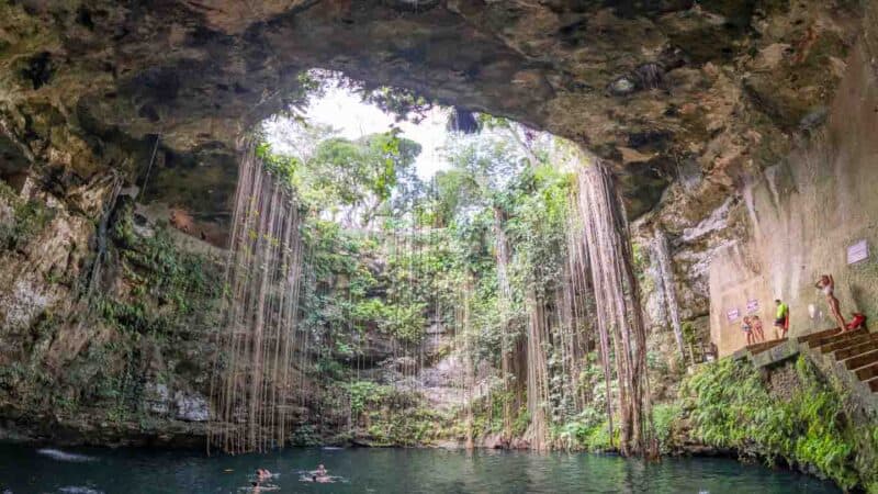 inside of cenote Il Kil with light filling the catherdal style cave area of the cenote