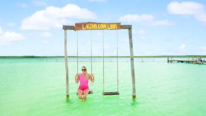 woman in a pink swim suit on the swings of Kaan Luum Lagoon