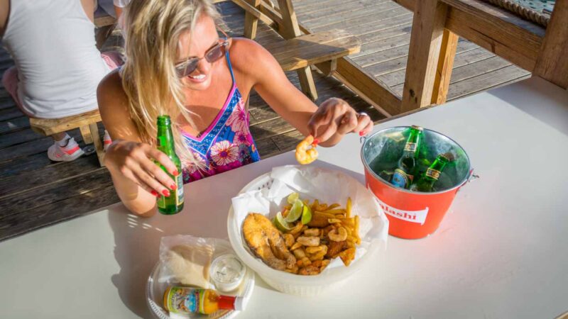 Woman eating local seafood at Zeerover restaurant located in Aruba