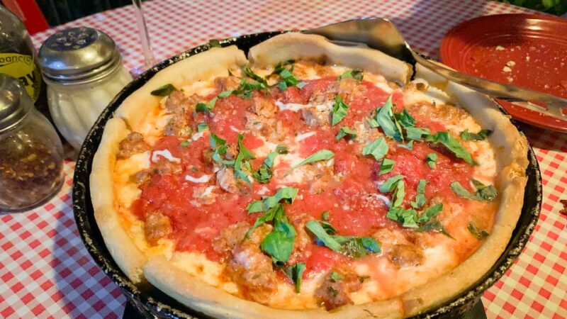 deep dish pizza with tomato sauce and basil on top at don Chendos of Playa del Carmen - Top Pizza restaurants