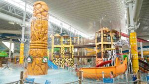 View of the indoor water park at the Kalahari with a large lion statue and many water slides