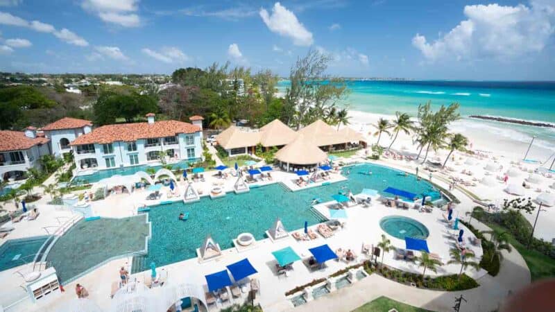 view from the rooftop looking down at the pool and pool chairs around the Sandals Royal Barbados Resort pool