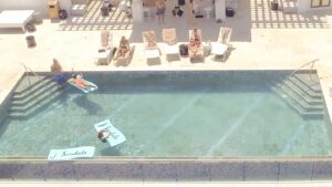 Drone photo of the Sky Bar pool rooftop with people swimming at Sandals Royal Barbados