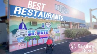 woman with a stroller standing in front of a pink building which is one of the best restaurants in St Petersburg FL - Featured Image