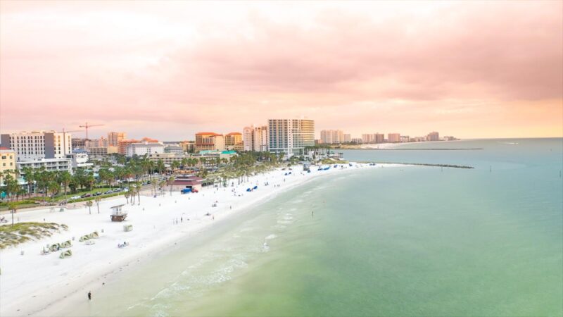 View from a helicopter over Clearwater Beach at sunset, white sand beach backed by buildings - Tourist attractions