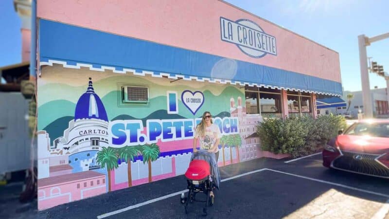 Woman standing infront of the pink exterior of La Croisette - St Petersburg FL Restaurant