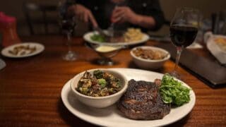 USDA Prime Ribeye on a plate with sides at 1200 chophouse - top restaurants in St Pete Beach FL