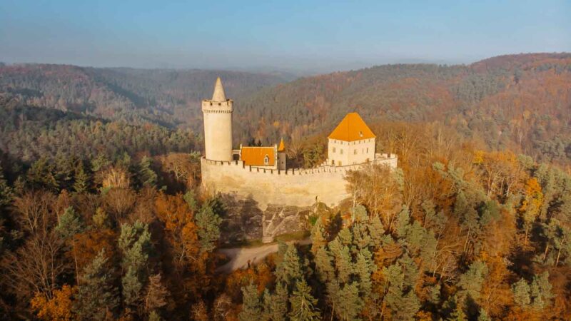 Aerial view of Kokorin Castle in the Czech Republic in the fall with trees with colorful foliage surrounding the castle