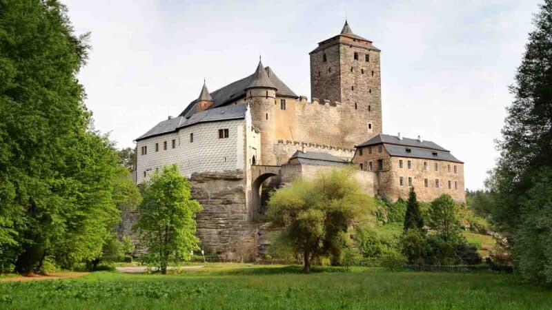 Exterior view of the Kost Castle with stone and sections of white building materials dating back many centuries