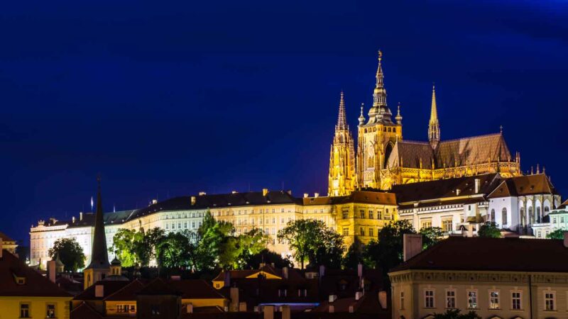 view of Prague Castle at night with the largest castle in Czech Republic lit up with lights